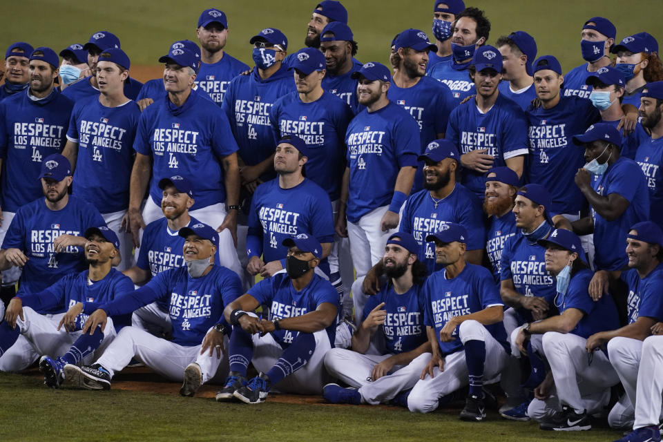 The Los Angeles Dodgers pose for a photo after the Dodgers clinched the NL West title with a 7-2 win over the Oakland Athletics in a baseball game Tuesday, Sept. 22, 2020, in Los Angeles. (AP Photo/Ashley Landis)