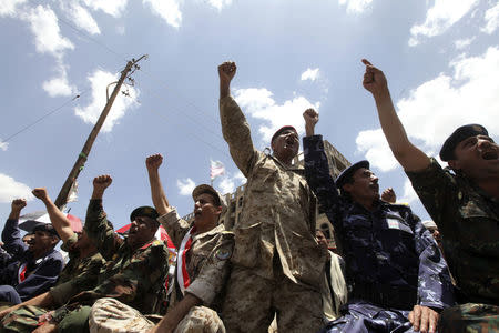 Army and police officers shout slogans as they sit on the ground during a protest to denounce fuel prices hikes and to demand for the resignation of the government in Sanaa August 22, 2014. RUETERS/Mohamed al-Sayaghi