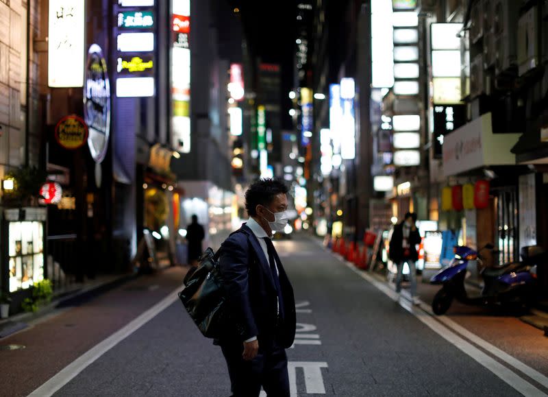 A man wearing a protective face mask, following an outbreak of the coronavirus disease, walks at Ginza shopping and amusement district in Tokyo