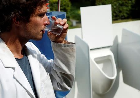 Belgian scientist Sebastiaan Derese drinks water from a machine that turns urine into drinkable water and fertilizer using solar energy, at the University of Ghent, Belgium, July 26, 2016. REUTERS/Francois Lenoir