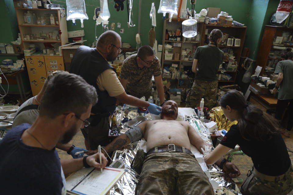 Medics help an injured Ukrainian serviceman in a frontline medical stabilization point in Zaporizhzhia region, Ukraine, Wednesday, July 26, 2023. (AP Photo/Kateryna Klochko)