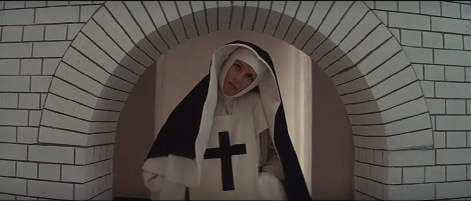 A nun tilting her head beneath an arch in "The Devils"