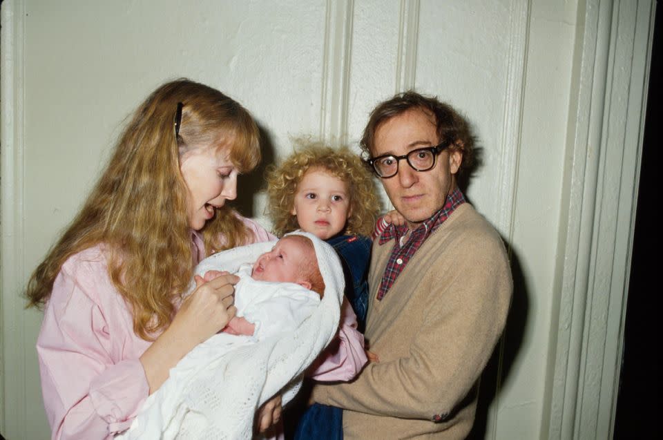 Woody Allen holding Dylan, his adopted daughter, beside his former wife and son in 1988. Source: Getty