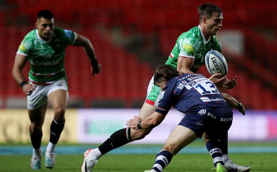 Josh Bassett of Leicester Tigers is challenged by Benhard Janse van Rensburg