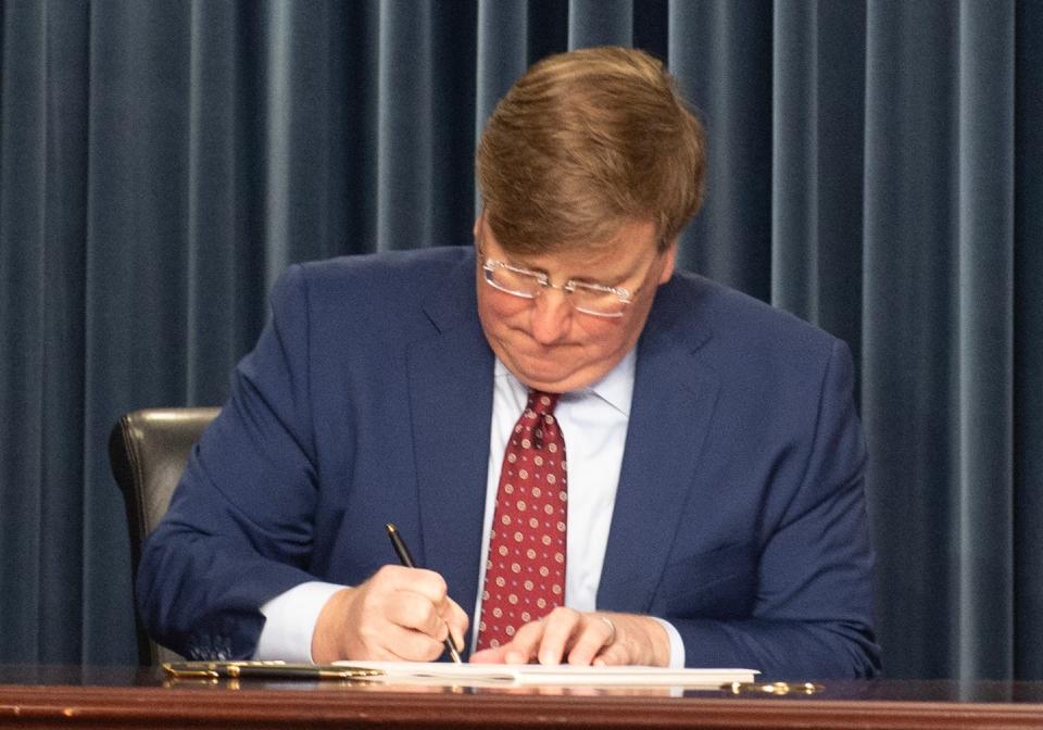 Gov. Tate Reeves signs a bill into law in Jackson on Tuesday, Feb. 28.