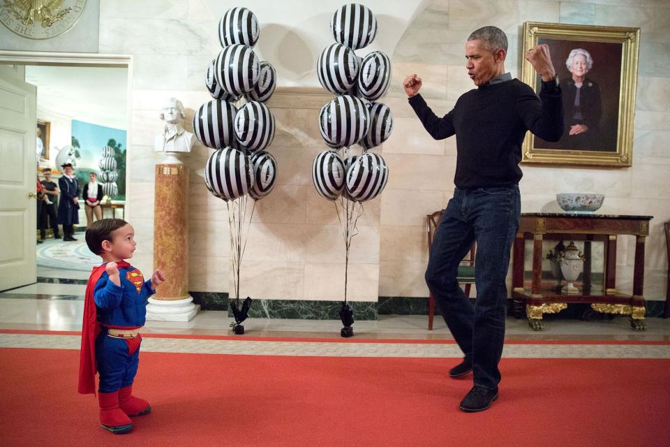 Obama flexes for Walker Earnest, son of White House press secretary Josh Earnest, during Halloween festivities at The White House on Oct. 31.