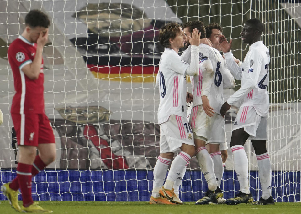 Diogo Jota, del Liverpool, se lamenta, mientras los jugadores del Real Madrid festejan, tras el partido de vuelta de los cuartos de final en la Liga de Campeones, el miércoles 14 de abril de 2021 (AP Foto/Jon Super)