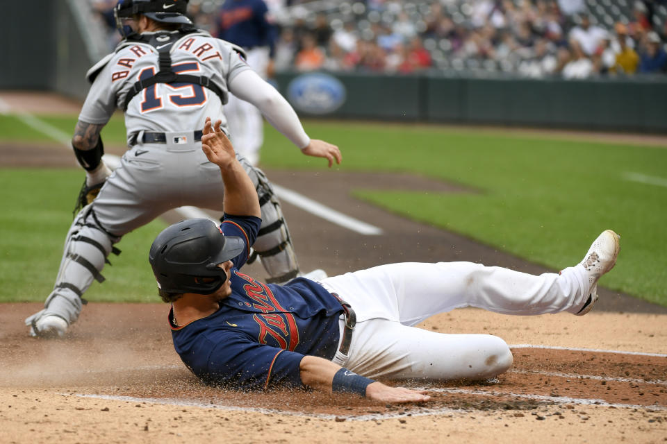 Minnesota Twins' Max Kepler scores as Detroit Tigers catcher Tucker Barnhart stands in front of the plate during the second inning of a baseball game Tuesday, May 24, 2022, in Minneapolis. (AP Photo/Craig Lassig)