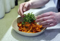 Jon Watts, demonstrates his cooking skills for the Associated Press by making a prawn linguini at a friends kitchen in Codicote, Welwyn, England, Thursday, April 15, 2021. Jon Watts was 18 years old when he woke up in a prison cell and decided he had to change. He enrolled in every course he could find, from mathematics to business. But he says it was a program founded by Prince Philip, the Duke of Edinburgh, that gave him a “passion for food” and a career as a chef when he got out of prison 3 1/2 years later. (AP Photo/Alastair Grant)