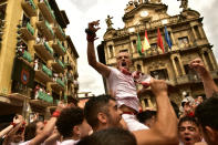 Revelers celebrate while waiting for the launch of the 'Chupinazo' rocket, to mark the official opening of the 2022 San Fermin fiestas in Pamplona, Spain, Wednesday, July 6, 2022. The blast of a traditional firework opens Wednesday nine days of uninterrupted partying in Pamplona's famed running-of-the-bulls festival which was suspended for the past two years because of the coronavirus pandemic. (AP Photo/Alvaro Barrientos)