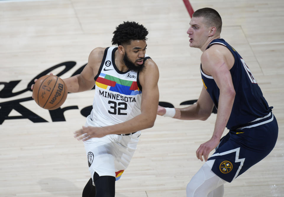 Minnesota Timberwolves center Karl-Anthony Towns, left, drives against Denver Nuggets center Nikola Jokic during the first half of Game 2 in an NBA basketball first-round playoff series Wednesday, April 19, 2023, in Denver. (AP Photo/David Zalubowski)