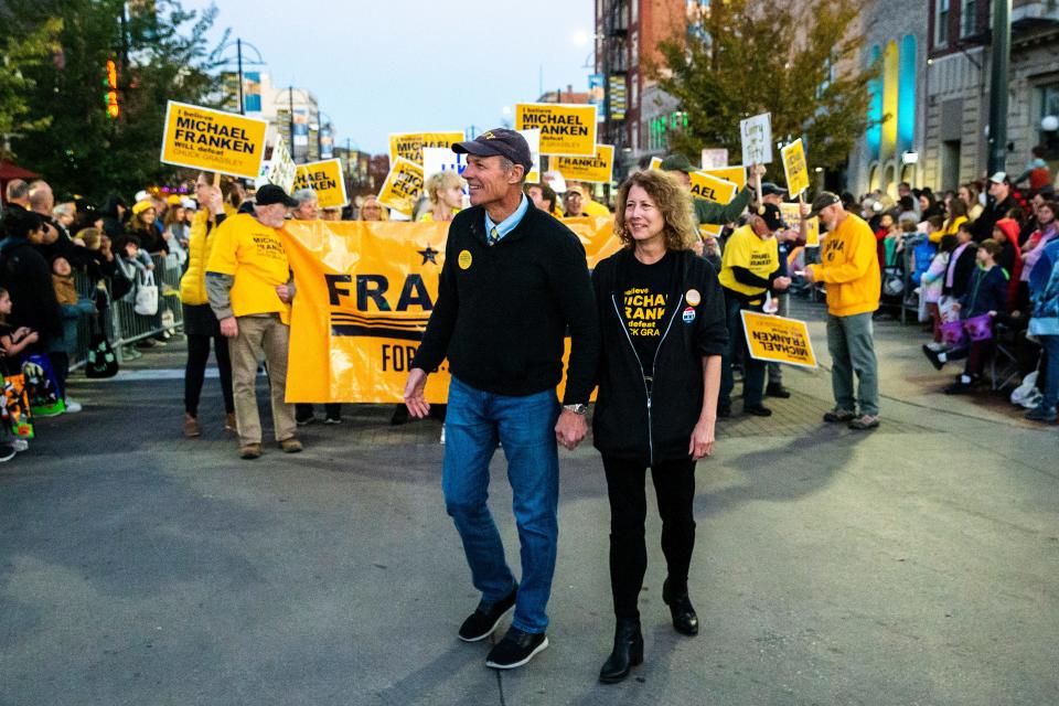 Iowa Democratic U.S. Senate candidate Mike Franken, left, walks with his wife Jordan during the University of Iowa Homecoming parade, Friday, Oct. 28, 2022, in Iowa City, Iowa.