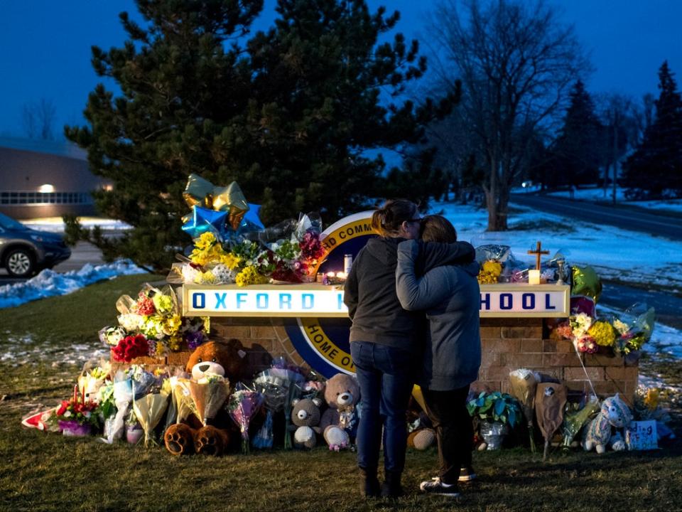 People mourn at a growing memorial outside Oxford High School (EPA)