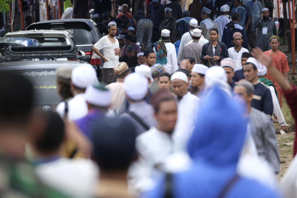 Pilgrims make their way through the crowd on a field where a mass congregation is supposed to be held in Gowa, South Sulawesi, Indonesia, Thursday, March 19, 2020. Indonesia halted the congregation of thousands of Muslim pilgrims and began quarantining and checking their health Thursday to prevent the spread of the new coronavirus. The vast majority of people recover from the new coronavirus. According to the World Health Organization, most people recover in about two to six weeks, depending on the severity of the illness. (AP Photo/Syaief)