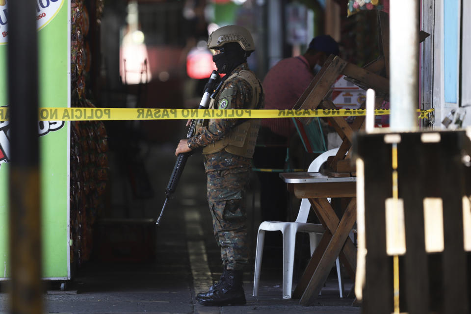 A soldier guards the perimeter of a crime scene at a small market in San Salvador, El Salvador, Sunday, March 27, 2022. El Salvador's congress has granted President Nayib Bukele request to declare a state of emergency, amid a wave of gang-related killings over the weekend. (AP Photo/Salvador Melendez)