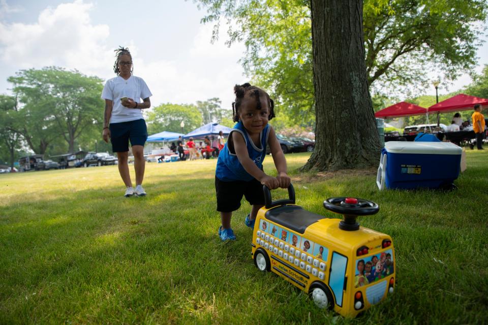 Danelle Six watches Jayce Six, 2, push his play school bus at the Juneteenth celebration in LaSalle Park in South Bend on June 17, 2023. 