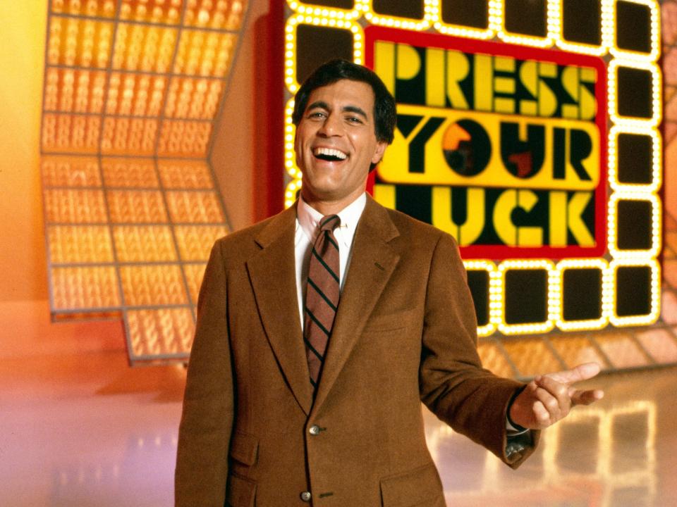 "Press Your Luck" host Peter Tomarken on set of the game show wearing brown suit