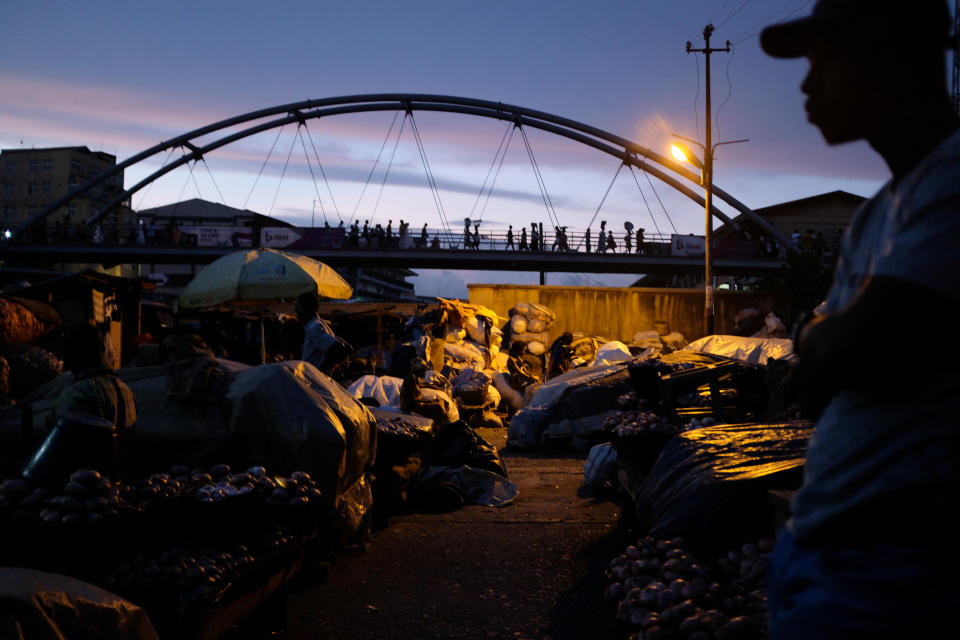 Traders walk across a footbridge in Adum market at nightfall in Kumasi, Ghana. (Photo: Francis Kokoroko/Reuters)