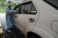 A health worker takes blood to perform an Enhanced Chemiluminescence Immunoassay (ECLIA) antibody test at a drive-thru COVID-19 testing facility at a hospital in metropolitan Manila, Philippines on Wednesday, July 8, 2020. Philippine President Rodrigo Duterte eased one of the world's longest lockdowns in the Philippine capital of more than 13 million people on June 1 after the economy shrank in the first quarter in its first contraction in more than two decades. (AP Photo/Aaron Favila)