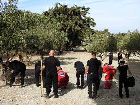 South Yorkshire police officers and members of the Greek rescue service (in red uniforms) investigate the ground before commencing excavating a site for Ben Needham, a 21 month old British toddler who went missing in 1991, on the island of Kos, Greece, September 26, 2016. REUTERS/Vassilis Triandafyllou