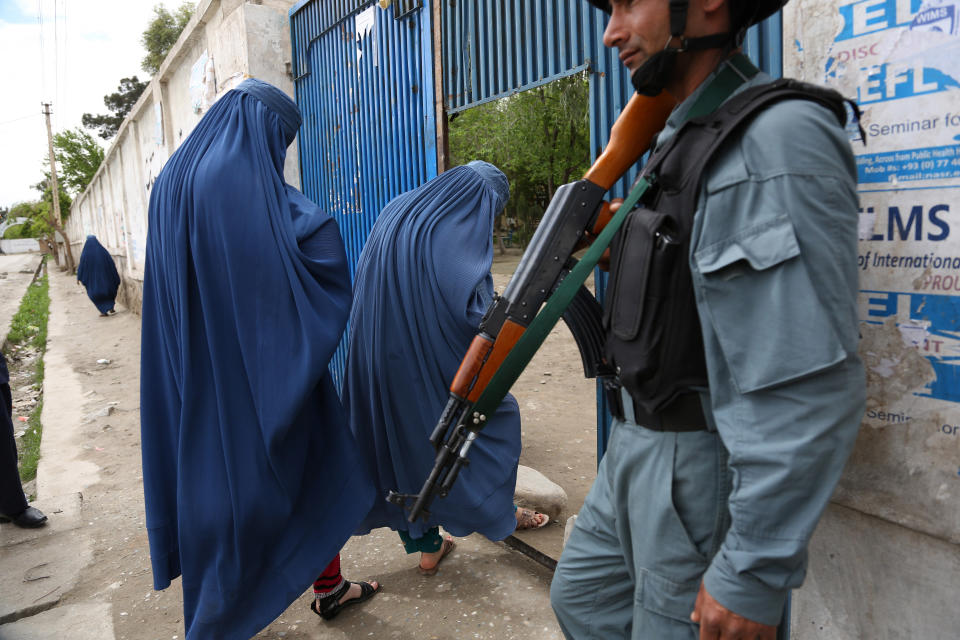 An Afghan policeman stands guard at a gate to a polling station in Jalalabad, east of Kabul, Afghanistan, Saturday, April 5, 2014. Across Afghanistan, voters turned out in droves Saturday to cast ballots in a crucial presidential election. The Taliban threatened to target voters and polling places, but there were few instances of violence. Women also turned out in large numbers. (AP Photo/Rahmat Gul)