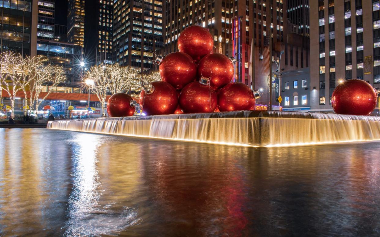 Spending Christmas in New York is a vacation that travelers will never forget. Here is our tips on what to do and where to stay to have an iconic winter vacation in the big city. Pictured: the huge red Christmas ornaments on sixth avenue fountain plaza