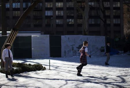 Schoolchildren play in melting snow at Madison Square Park, in the Manhattan borough of New York City, March 9, 2015. REUTERS/Mike Segar
