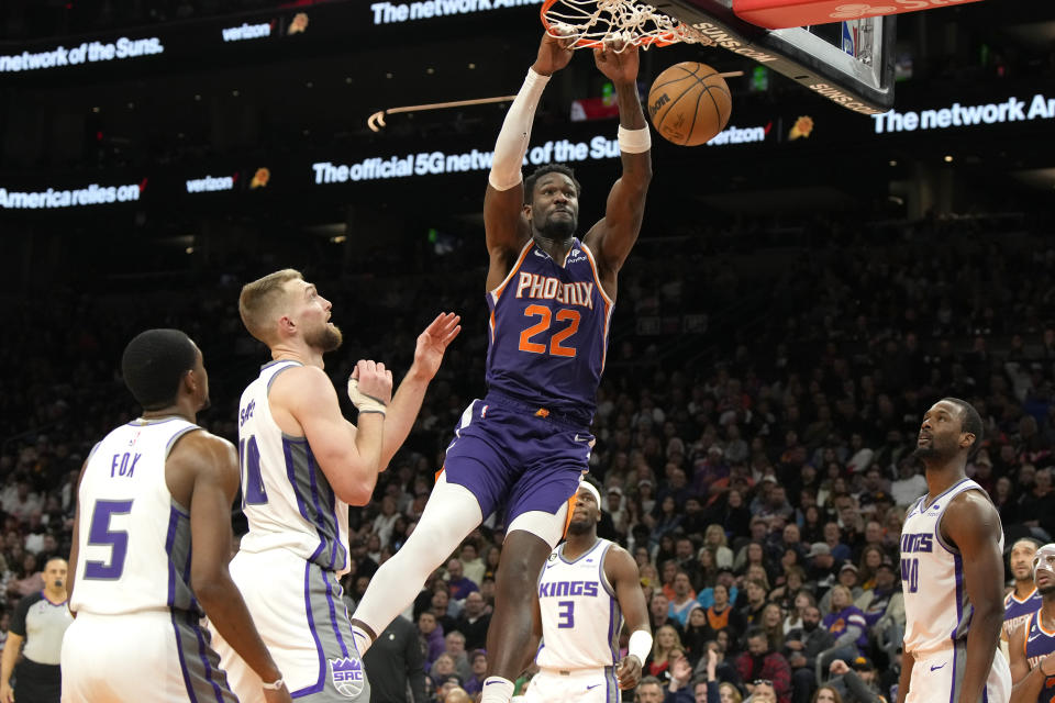 Phoenix Suns center Deandre Ayton (22) dunks over Sacramento Kings guard De'Aaron Fox (5), forward Domantas Sabonis, guard Terence Davis (3), and forward Harrison Barnes during the second half of an NBA basketball game, Tuesday, Feb. 14, 2023, in Phoenix. The Suns won 120-109. (AP Photo/Rick Scuteri)