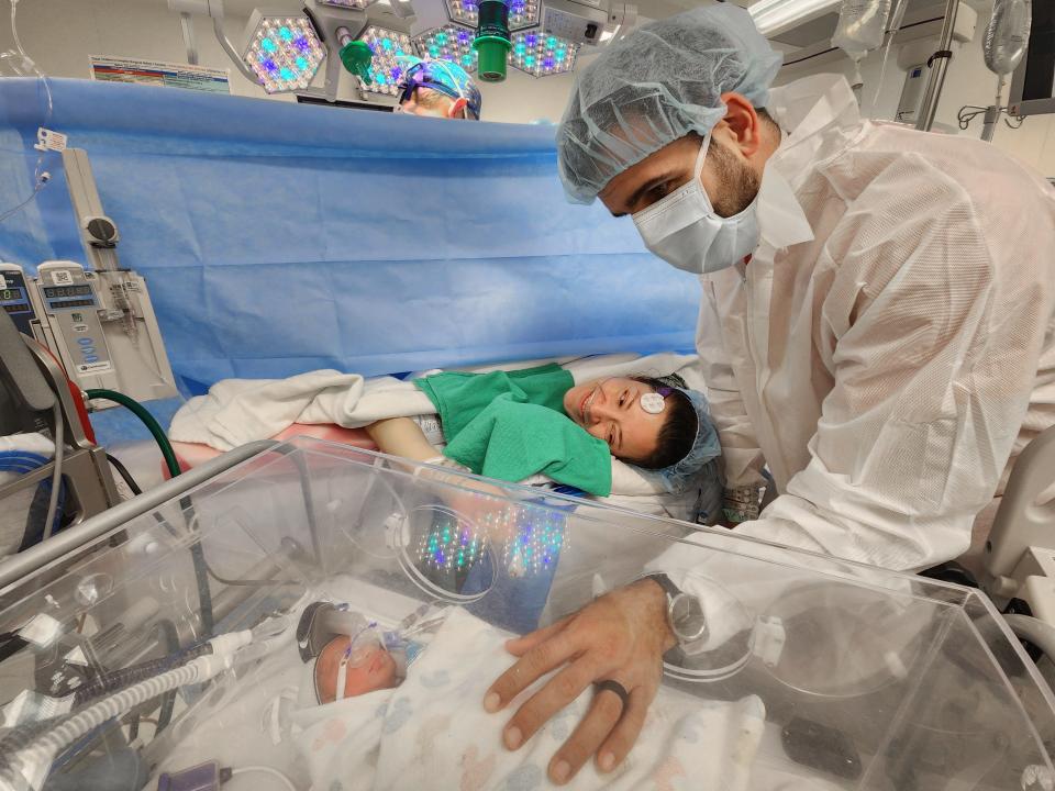 Jonathan Sandhu outstretches his arm to touch one of his new babies at Texas Children's Hospital.