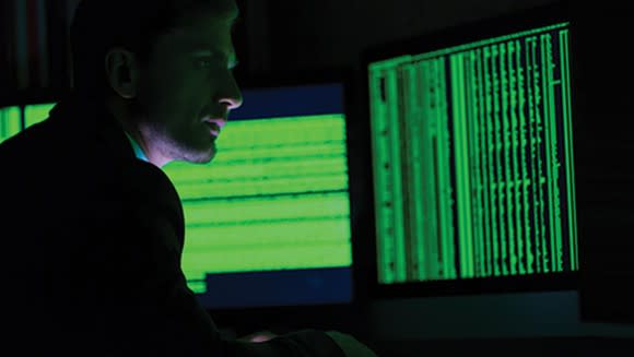 Man sitting in front of a green computer screen