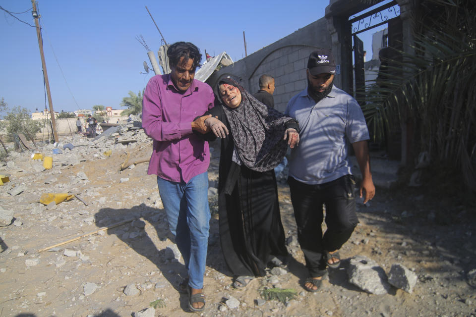 Palestinians evacuate a wounded woman after an Israeli airstrike in Rafah, Gaza Strip, Friday, Oct. 13, 2023. (AP Photo/Hatem Ali)