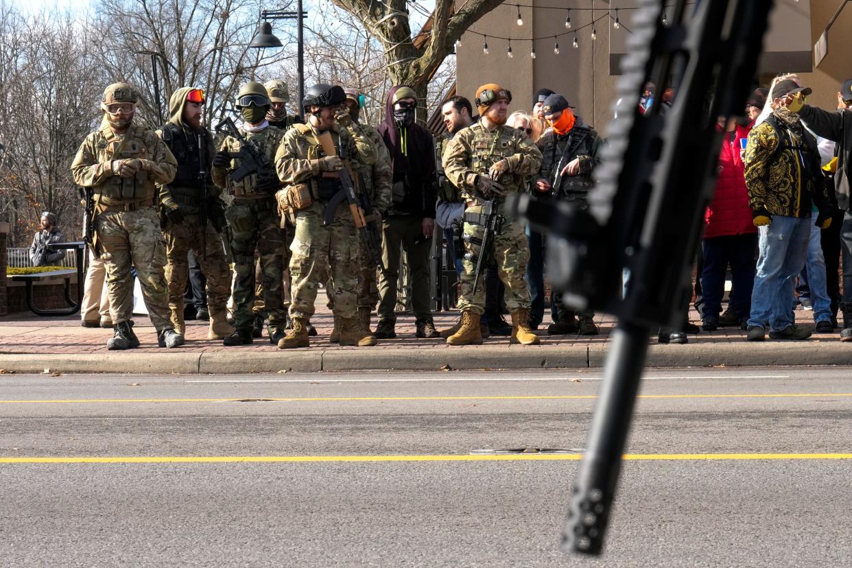 Columbus, Ohio, United States; A counter protestors rifle is seen in the foreground while Proud Boys protest on High Street outside of Our Lady of Peace Catholic Church on Saturday morning.