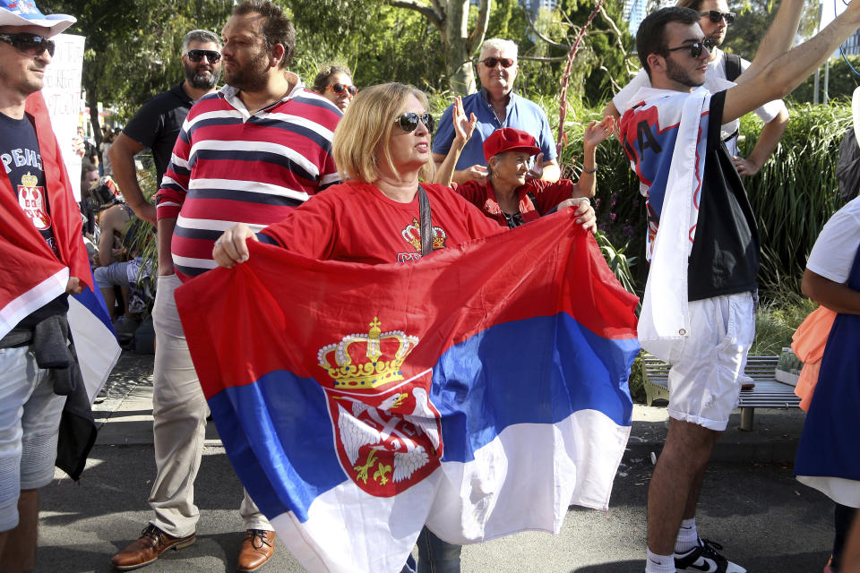 Protesters and fans of Serbia's Novak Djokovic gather outside the Park Hotel, used as an immigration detention hotel where Djokovic is confined in Melbourne, Australia, Saturday, Jan. 8, 2022. He has been confined to the detention hotel in Melbourne pending a court hearing on Monday, a week before the start of the Australian Open. Djokovic was barred from entering the country late Wednesday when federal border authorities at the Melbourne airport rejected his medical exemption to Australia's strict COVID-19 vaccination requirements. (AP Photo/Hamish Blair)