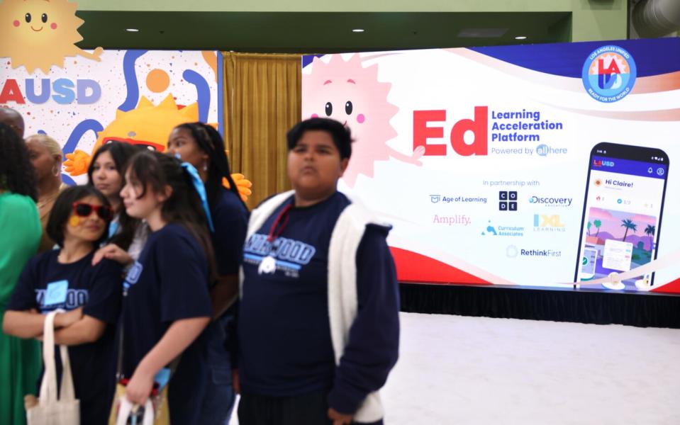 Students stand in front of a brightly colored poster.