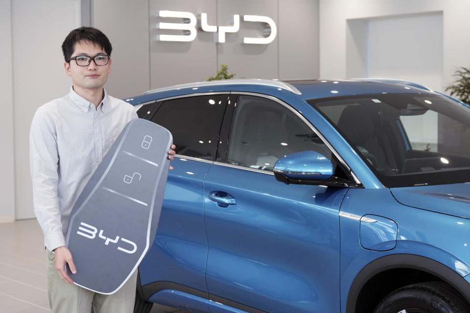 Ohta, who just bought a brand new BYD ATTO 3 electric sports utility vehicle, poses with his car and the symbolic key at a BYD dealership on April 4, 2023, in Yokohama near Tokyo. BYD Auto is part of a wave of Chinese electric car exporters that are starting to compete with Western and Japanese brands in their home markets. They bring fast-developing technology and low prices that Tesla Inc.'s chief financial officer says “are scary.” (AP Photo/Eugene Hoshiko)