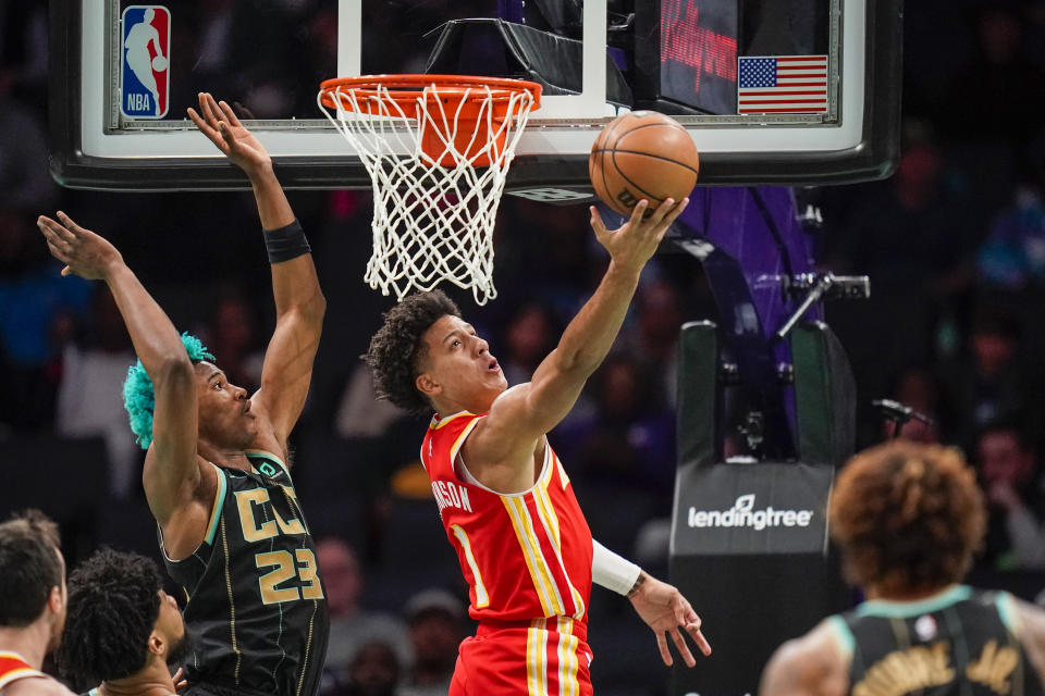 Atlanta Hawks forward Jalen Johnson, back right, makes a reverse layup past Charlotte Hornets forward Kai Jones, left, during the first half of an NBA basketball game Friday, Dec. 16, 2022, in Charlotte, N.C. (AP Photo/Rusty Jones)