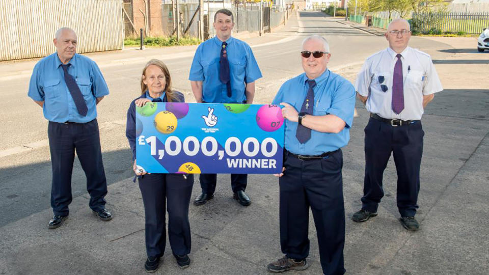 Five bus drivers are pictured with a check from EuroMillions lottery.