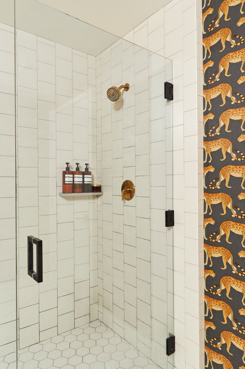 Bath product neatly lined up in shower with glass door.