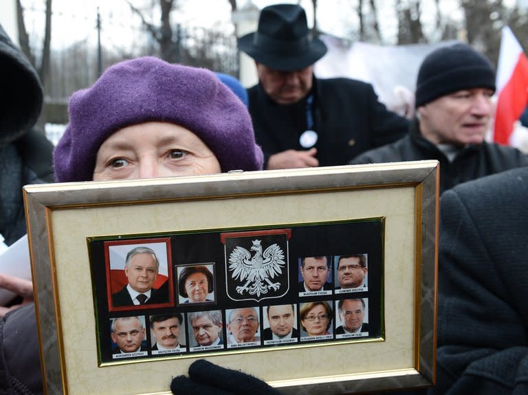 A demonstrator holds portraits of 11 of the 96 victims of the April 10, 2010 air crash in Russia of an official jet in which then Polish president Lech Kaczynski was killed, during a demonstration on April 9, 2013 in front of the Russian embassy in Warsaw. Poland's opposition leader laid flowers Wednesday in honour of Lech, who was his twin