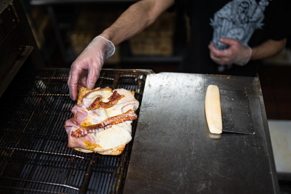 Cade Wright plucks a sandwich from an oven at Cheba Hut on Laurel Street in Fort Collins on Feb. 28, 2023.