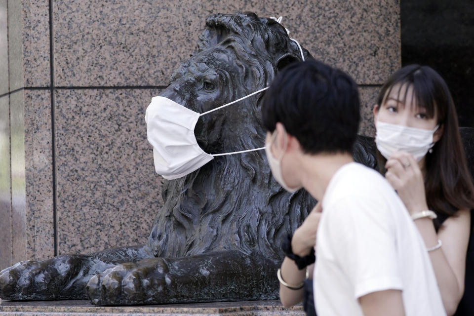 A landmark lion statue of a department store placed a protective mask is seen Wednesday, Aug. 12, 2020, in Tokyo. The Japanese capital confirmed more than 200 new coronavirus cases on Wednesday. (AP Photo/Eugene Hoshiko)