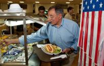 US Secretary of Defense Leon Panetta reaches for a packet of mustard and relish as he takes a hot dog for lunch during his visit to Camp Victory in Baghdad. American forces are pursuing Iran-backed insurgents in Iraq, Defence Secretary Leon Panetta said in Baghdad on Monday as US deaths spike nearly a year after US troops formally ended combat operations