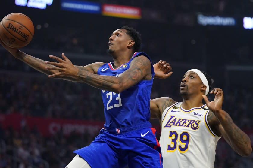 Los Angeles Clippers guard Lou Williams, left, shoots in front of Lakers center Dwight Howard.