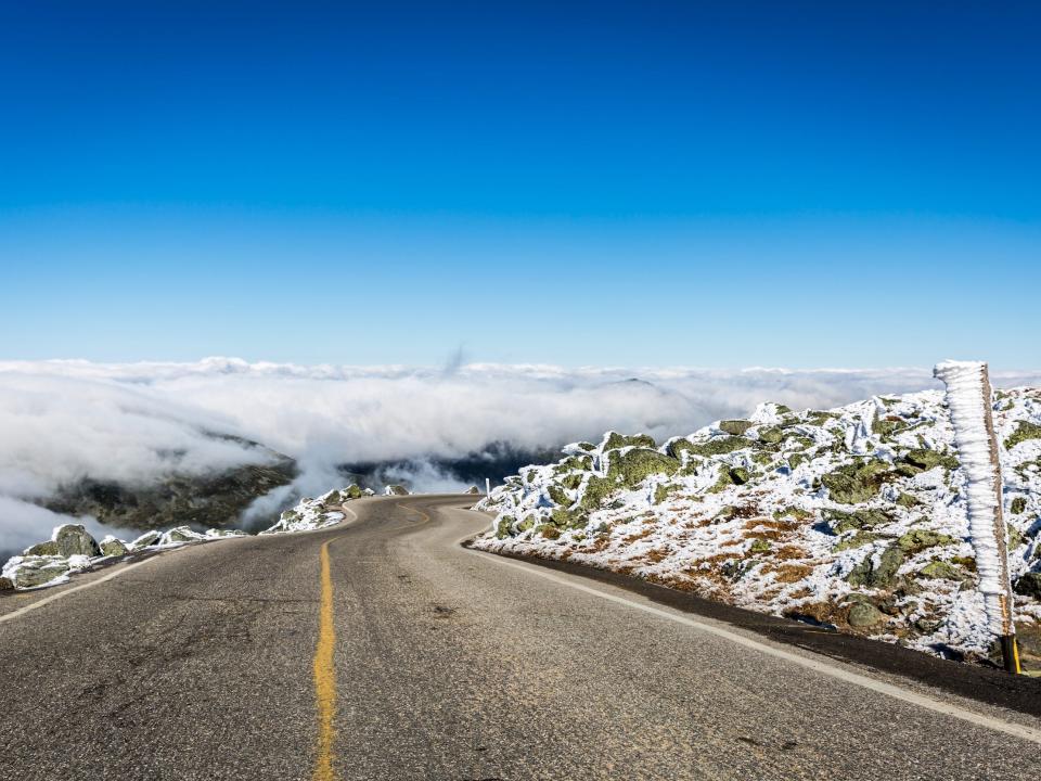 Mount Washington Auto Road at Mount Washington summit in New Hampshire. The sky is clear blue and the road is above the clouds.