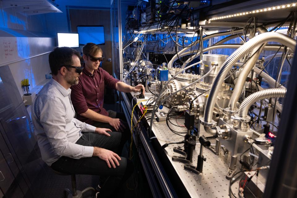 Dylan Yost, an associate professor of physics, with Ph.D. candidate Ryan Bullis and master's degree student William Tavis, explore extremely precise measurements of hydrogen atoms with lasers on Feb. 20 at Colorado State University in Fort Collins.