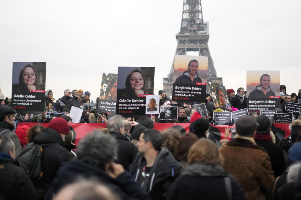 FILE - People hold portraits of French hostages in Iran Cecile Kohler, left, and Benjamin Briere during a protest in Paris, Saturday, Jan. 28, 2023. Two French citizens imprisoned in Iran have been freed, France's foreign minister said Friday. Benjamin Briere and Bernard Phelan, who both had been held in a prison in Mashad, in northwest Iran, were heading to Paris, a statement from Foreign Minister Catherine Colonna said. (AP Photo/Thibault Camus, File)