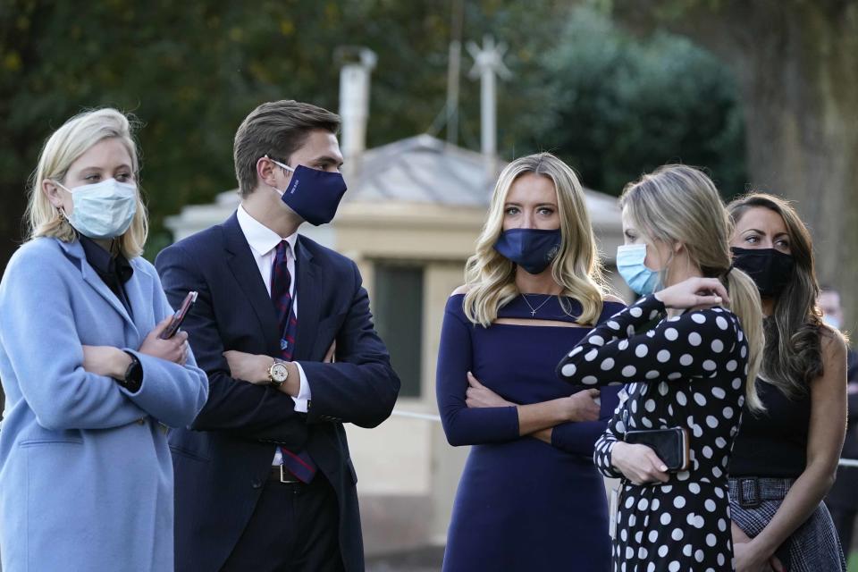 White House press secretary Kayleigh McEnany, third from left, waits with others as President Donald Trump prepares to leave the White House to go to Walter Reed National Military Medical Center after he tested positive for COVID-19, Friday, Oct. 2, 2020, in Washington. (AP Photo/Alex Brandon)