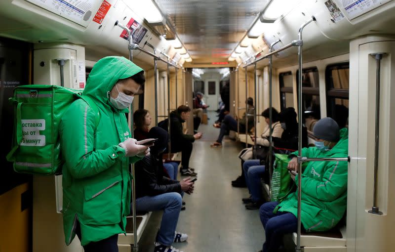 FILE PHOTO: Ruslan, 22, a courier of Delivery Club food delivery service rides an underground train in Moscow