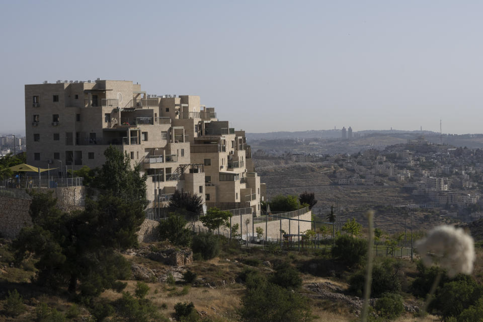 Palestinian buildings are seen at right, behind a section of the West Bank Jewish settlement of Efrat, foreground, Thursday, June 9, 2022. Israeli settlers in the occupied West Bank may soon have a taste of the military rule that Palestinians have been living under for 55 years. A looming end-of-month deadline to extend legal protections to Jewish settlers has put Israel’s government on the brink of collapse and drawn widespread warnings that the territory could be plunged into chaos. (AP Photo/Maya Alleruzzo)