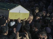 Turkey's President Recep Tayyip Erdogan helps to carry the coffin of a victim after an earthquake hit Elazig, eastern Turkey, Friday, during the funeral procession for the quake victims Salih Civelek and Aysegul Civelek, Saturday, Jan. 25, 2020. Rescuers continued searching for people buried under the rubble of collapsed buildings while emergency workers and security forces distributed tents, beds and blankets in the affected areas. Mosques, schools, sports halls and student dormitories were opened for hundreds who left their homes after the quake. (Presidential Press Service via AP, Pool)